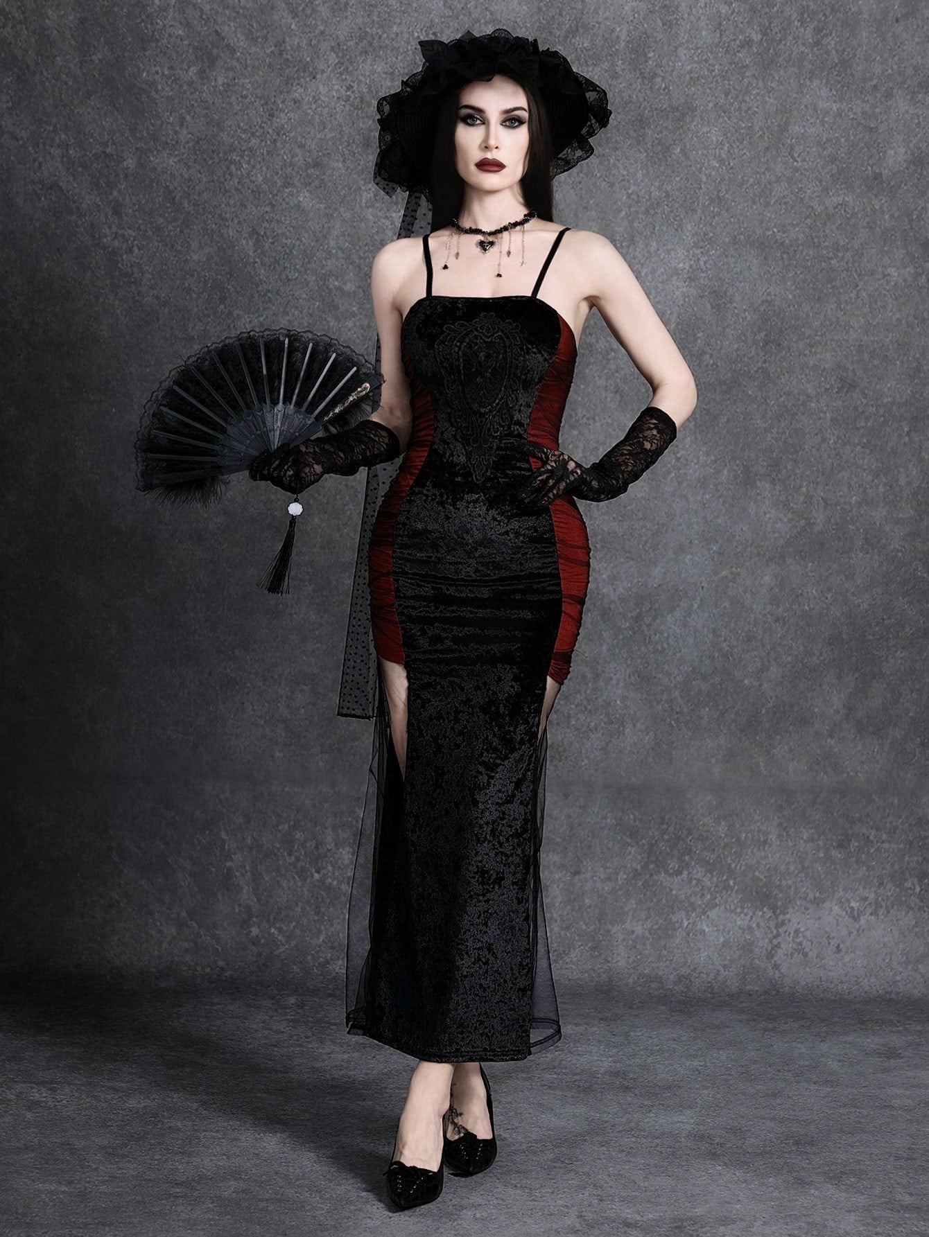 Women wearing an elegant black backless midi cami dress with slender spaghetti straps and a side split thigh hem.