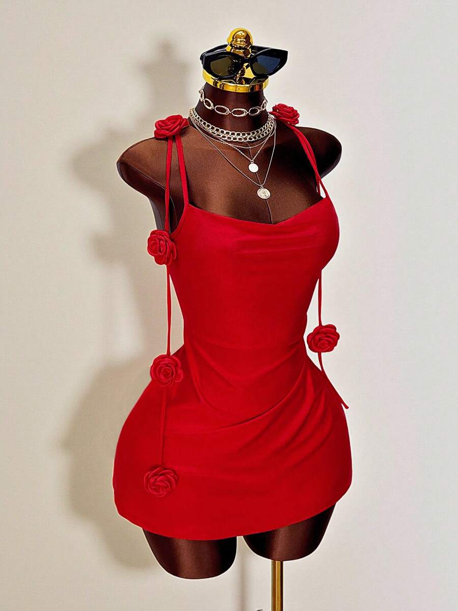 Women's bodycon mini dress featuring a 3D rose accent, thin spaghetti straps, and an open back design.