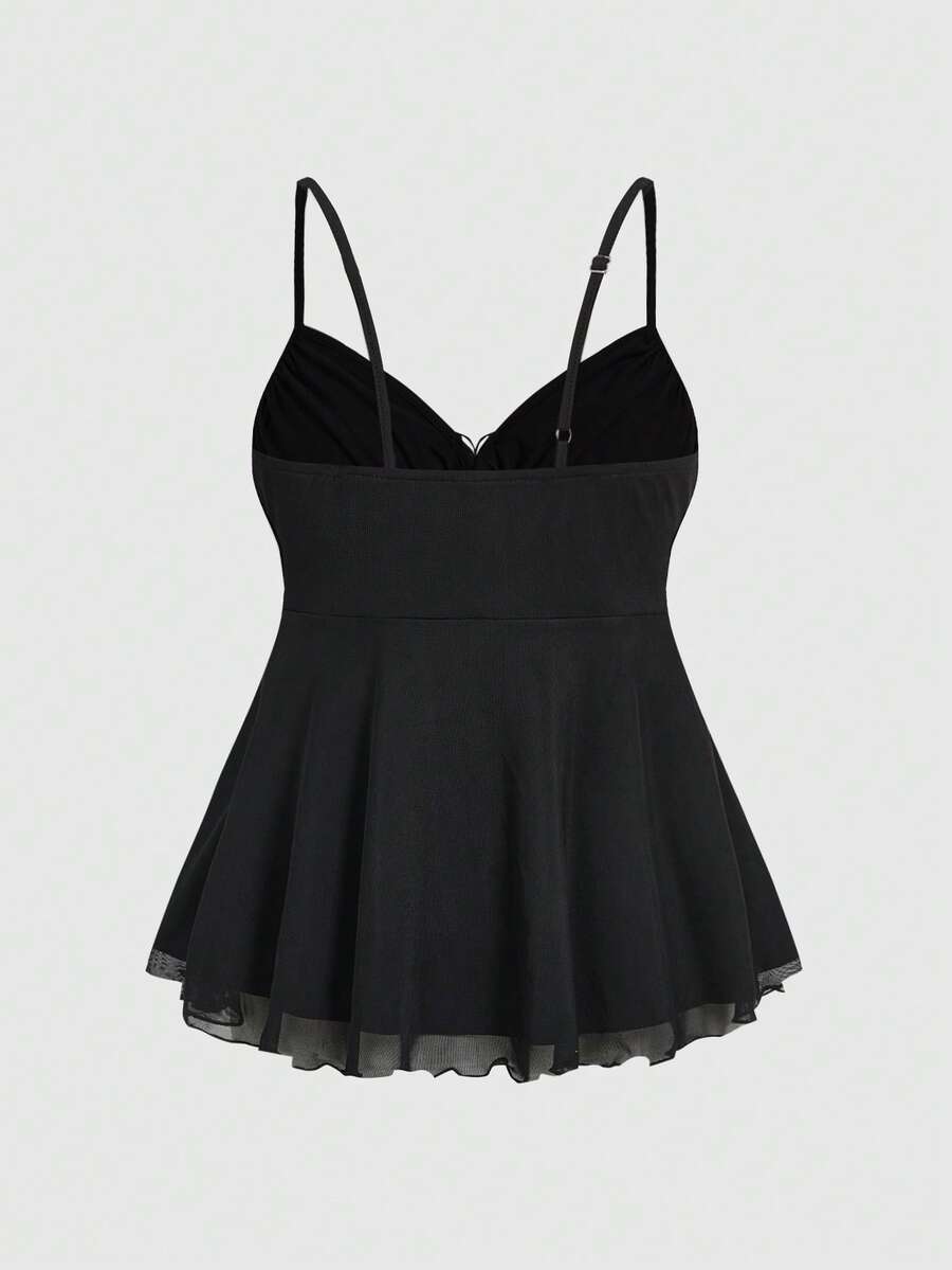 Women's black slim-fit camisole top featuring ruched body design, decorative chain accent, ruffle hem, and cold-shoulder spaghetti straps.