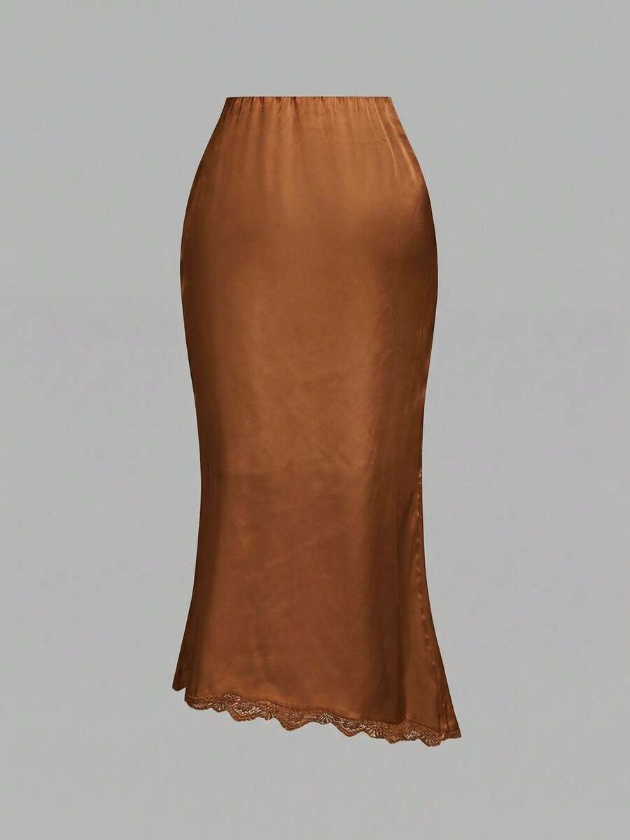 Women's elegant pink satin asymmetrical long skirt featuring contrast lace patchwork, ruched knot detailing, and a mid-waist mermaid cut.
