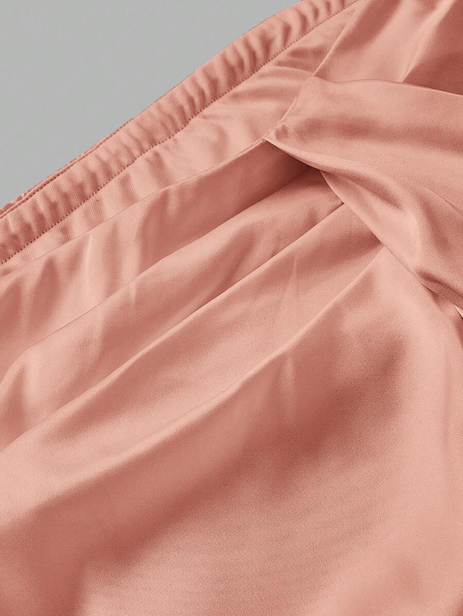 Women's elegant pink satin asymmetrical long skirt featuring contrast lace patchwork, ruched knot detailing, and a mid-waist mermaid cut.