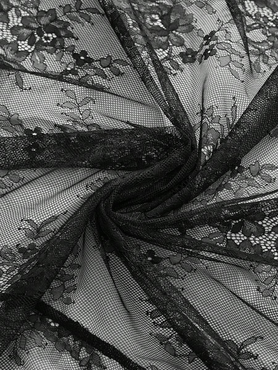 Woman wearing a black sheer lace maxi dress with spaghetti straps, high waist split thigh, and asymmetrical hem.