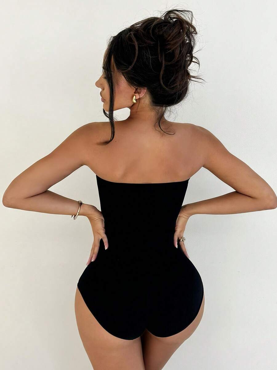 Black seamless shapewear bandeau bodysuit featuring strong waist support in knitted stretch fabric.
