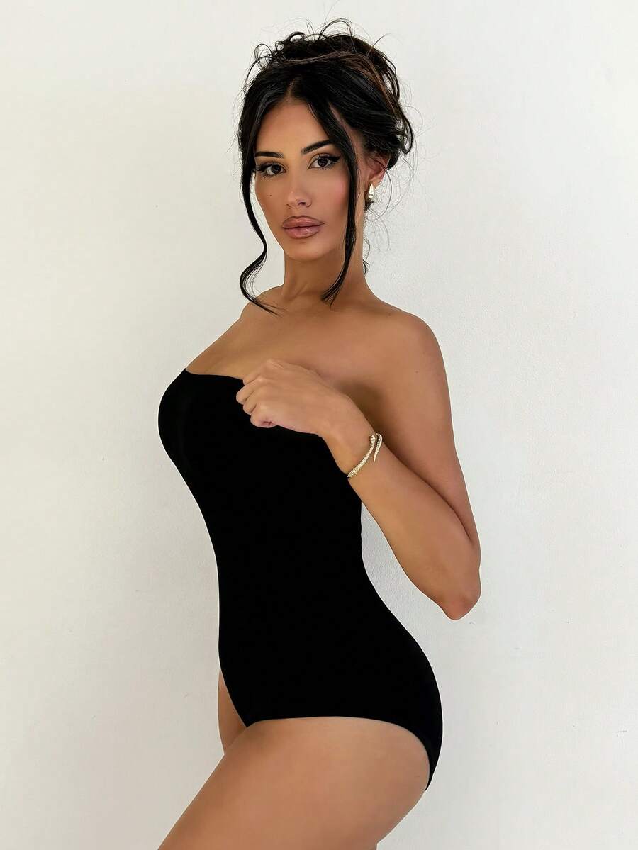 Black seamless shapewear bandeau bodysuit featuring strong waist support in knitted stretch fabric.