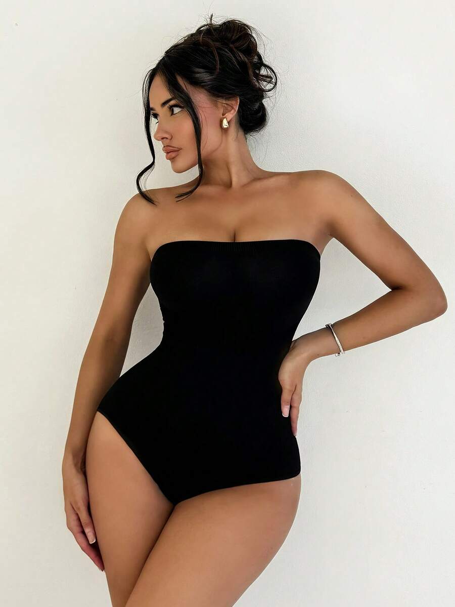 Black seamless shapewear bandeau bodysuit featuring strong waist support in knitted stretch fabric.