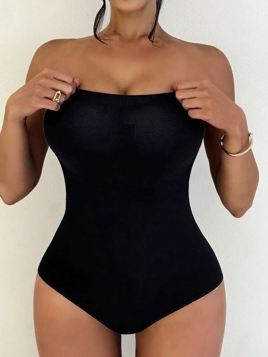 Black seamless shapewear bandeau bodysuit featuring strong waist support in knitted stretch fabric.
