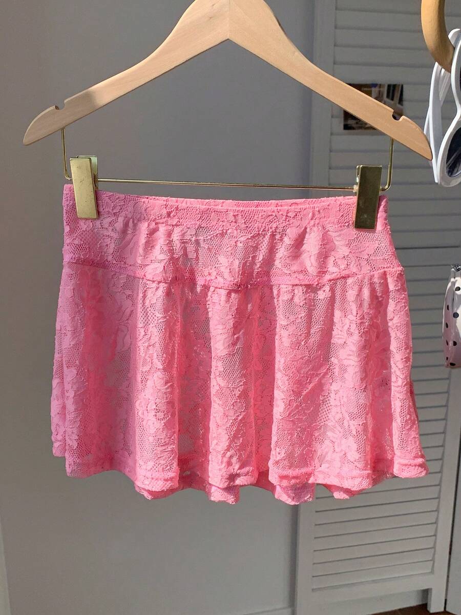 Women's black semi-sheer knitted lace mini skirt featuring a flared ruffle hem and low waist design