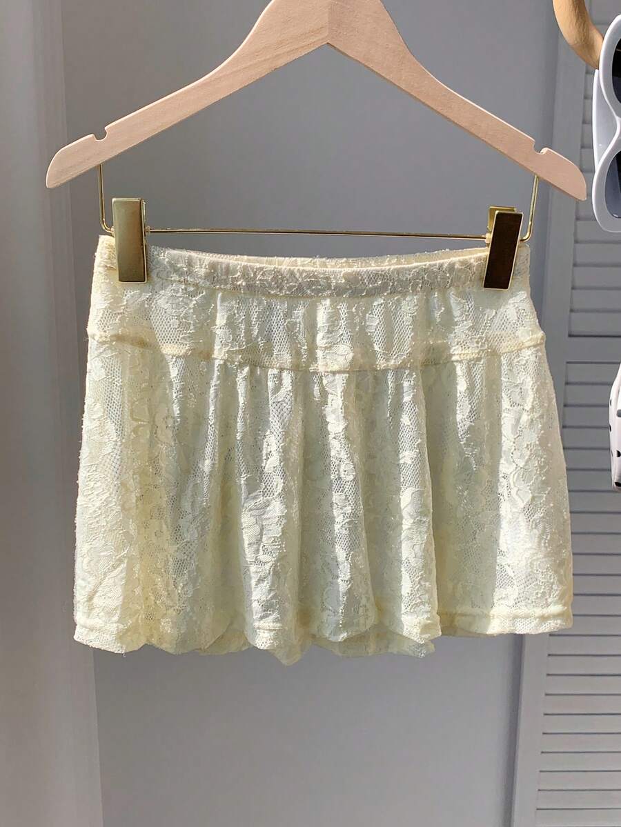 Women's black semi-sheer knitted lace mini skirt featuring a flared ruffle hem and low waist design