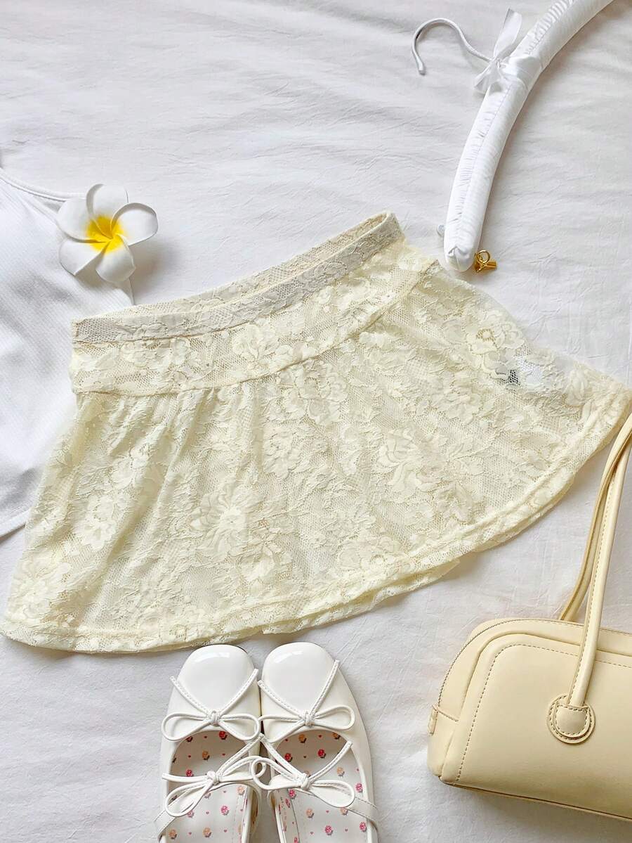 Women's black semi-sheer knitted lace mini skirt featuring a flared ruffle hem and low waist design