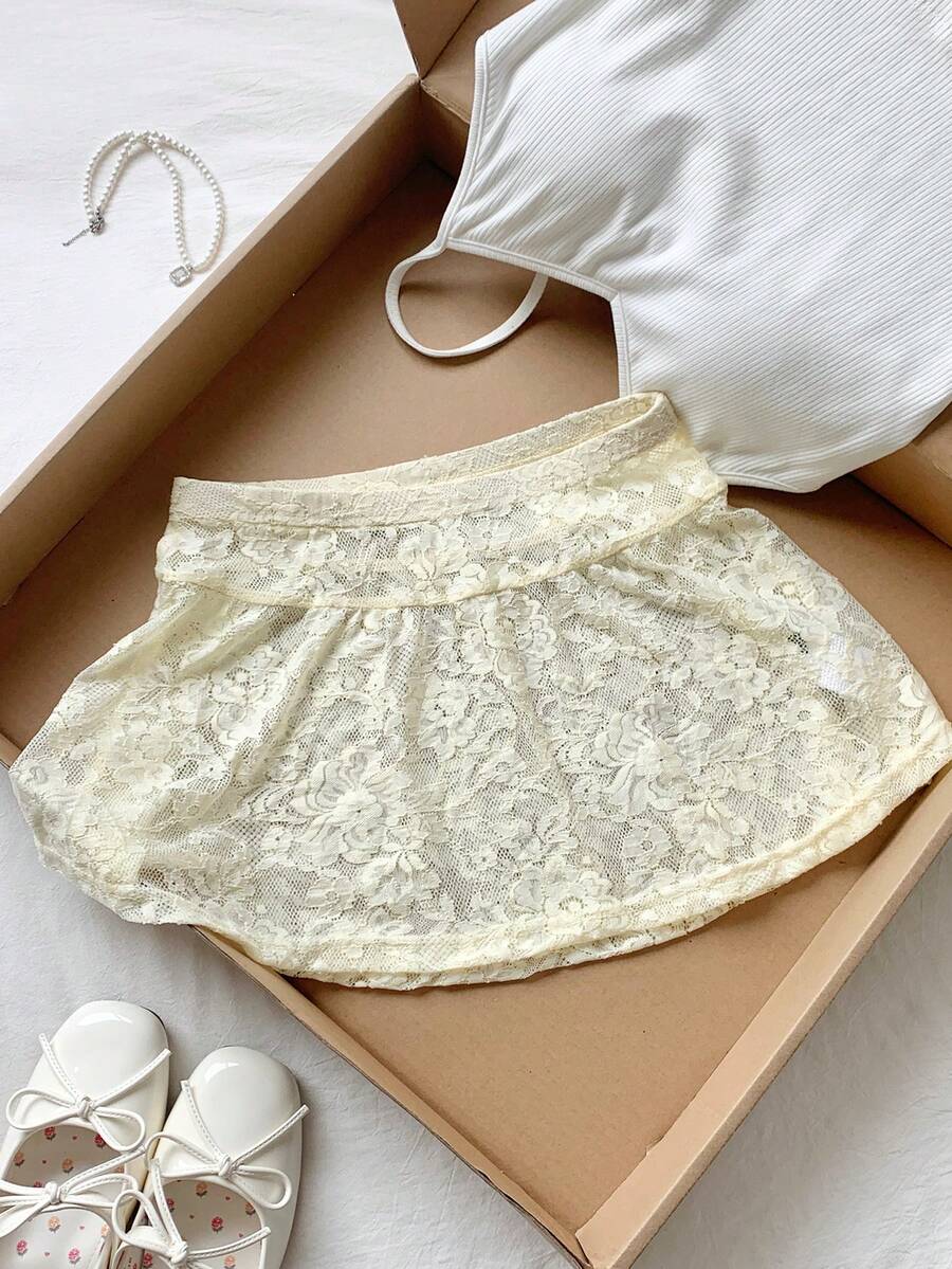 Women's black semi-sheer knitted lace mini skirt featuring a flared ruffle hem and low waist design