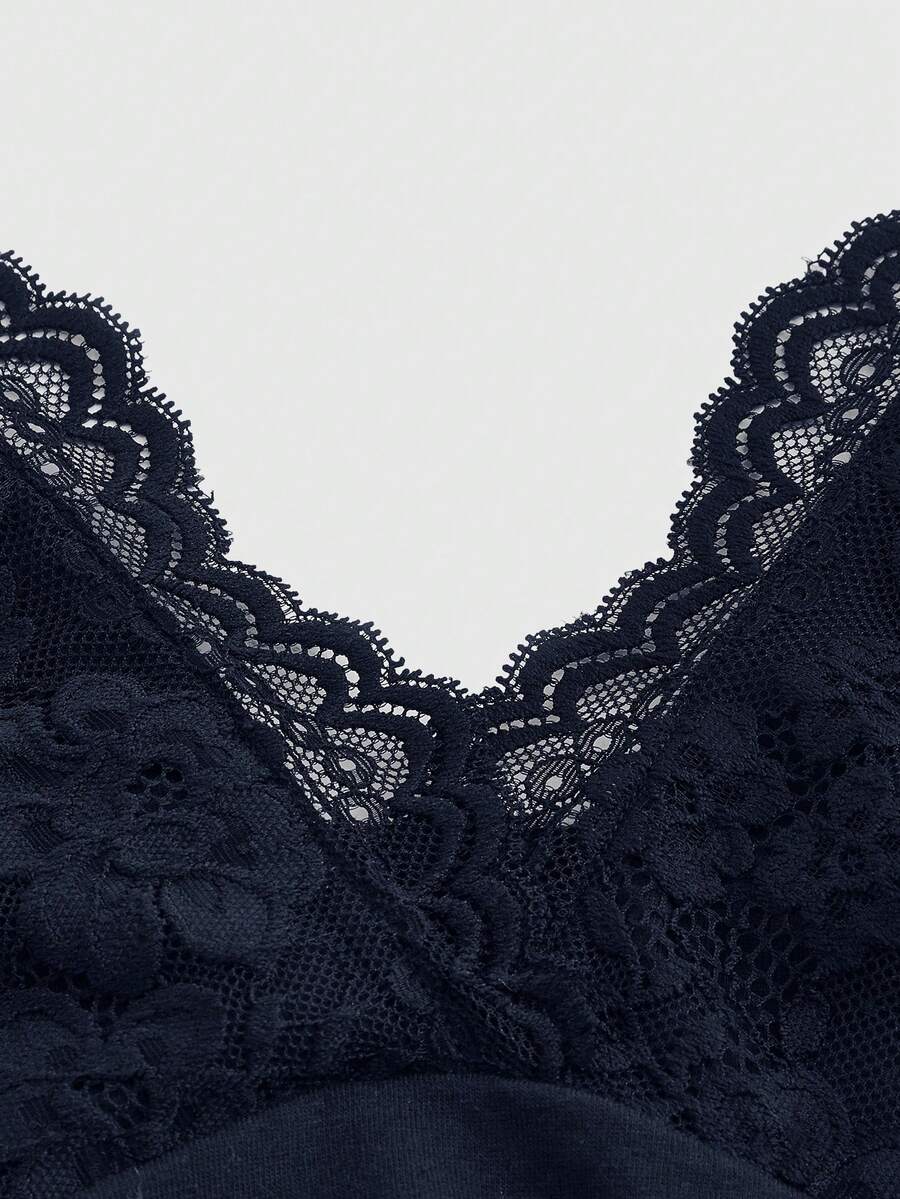 A women's black backless halter top featuring contrast lace trim, ruched front detail, and slim fit soft knitted fabric.