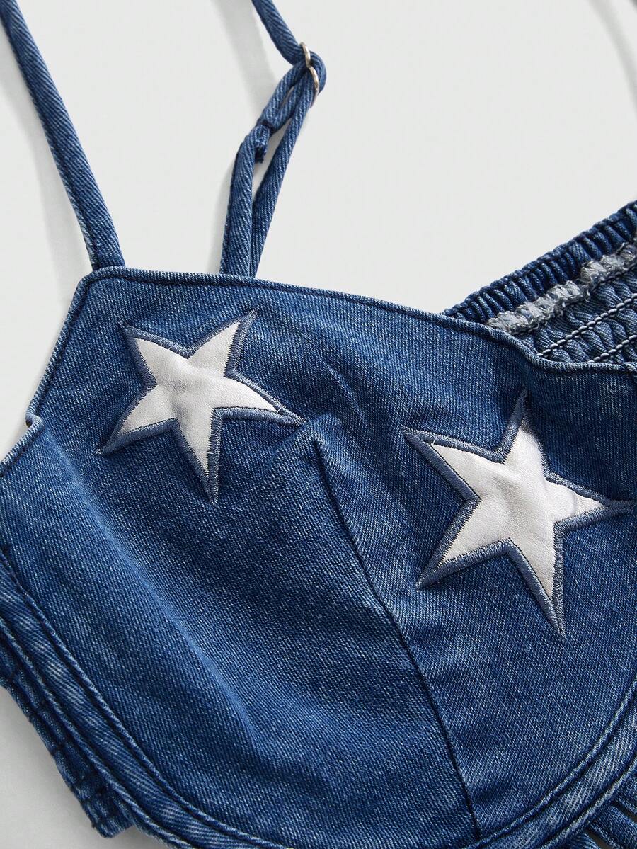 Blue denim camisole top for women featuring star patch detailing, fringe tassel asymmetrical hem, and spaghetti straps.
