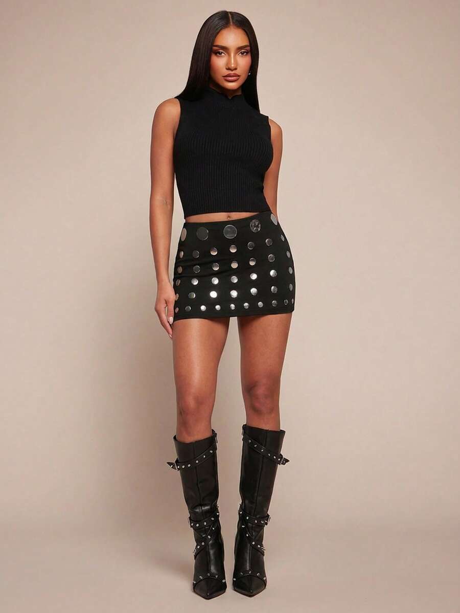 Women's black bodycon mini skort featuring a low waist, pleated side split hem, zipper closure, and built-in shorts.