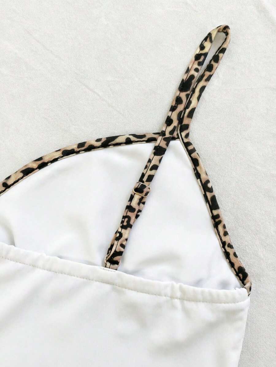 A women's solid slim fit camisole top with delicate contrast lace trim around the neckline and spaghetti straps.
