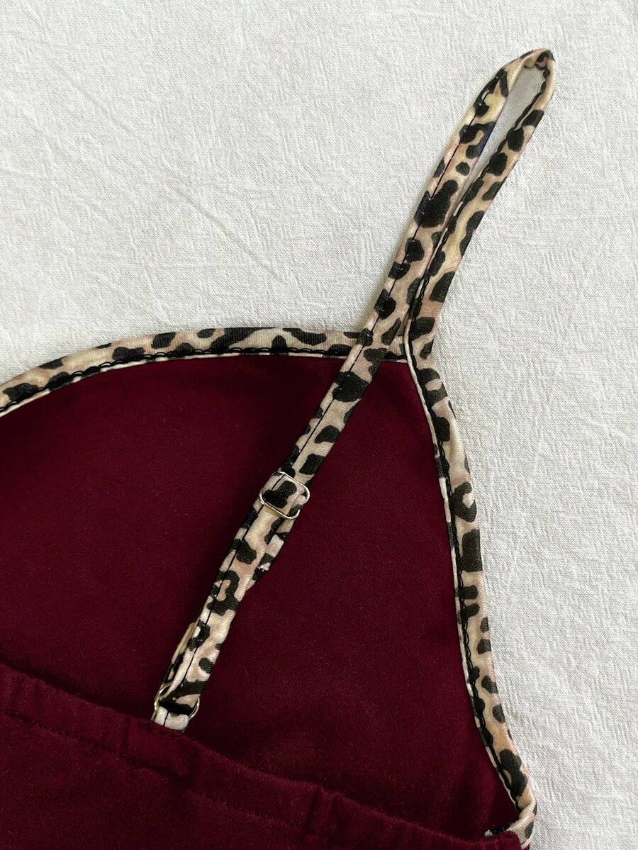 A women's solid slim fit camisole top with delicate contrast lace trim around the neckline and spaghetti straps.
