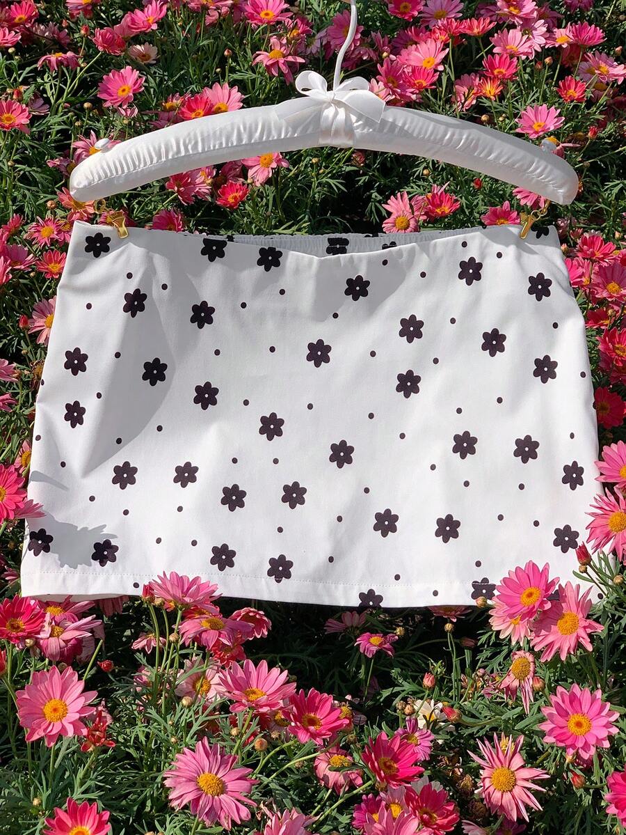 Women's white 100% cotton low waist mini skirt featuring a tropical print and zipper detail.
