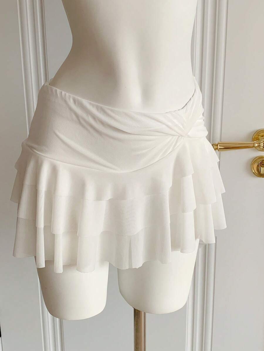 Black tiered ruffle mini cake skirt for women featuring a mid-waist pleated design and layered ruffle hem.