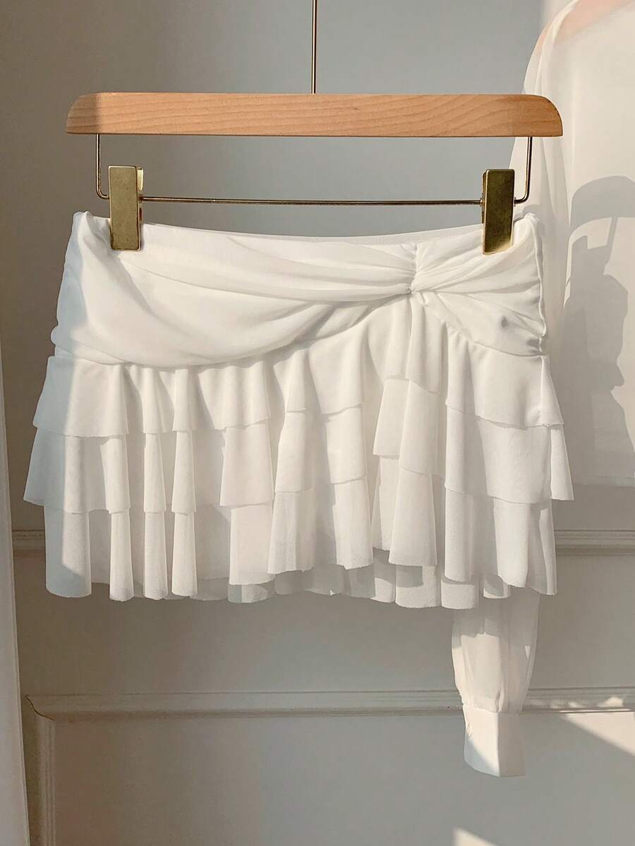 Black tiered ruffle mini cake skirt for women featuring a mid-waist pleated design and layered ruffle hem.