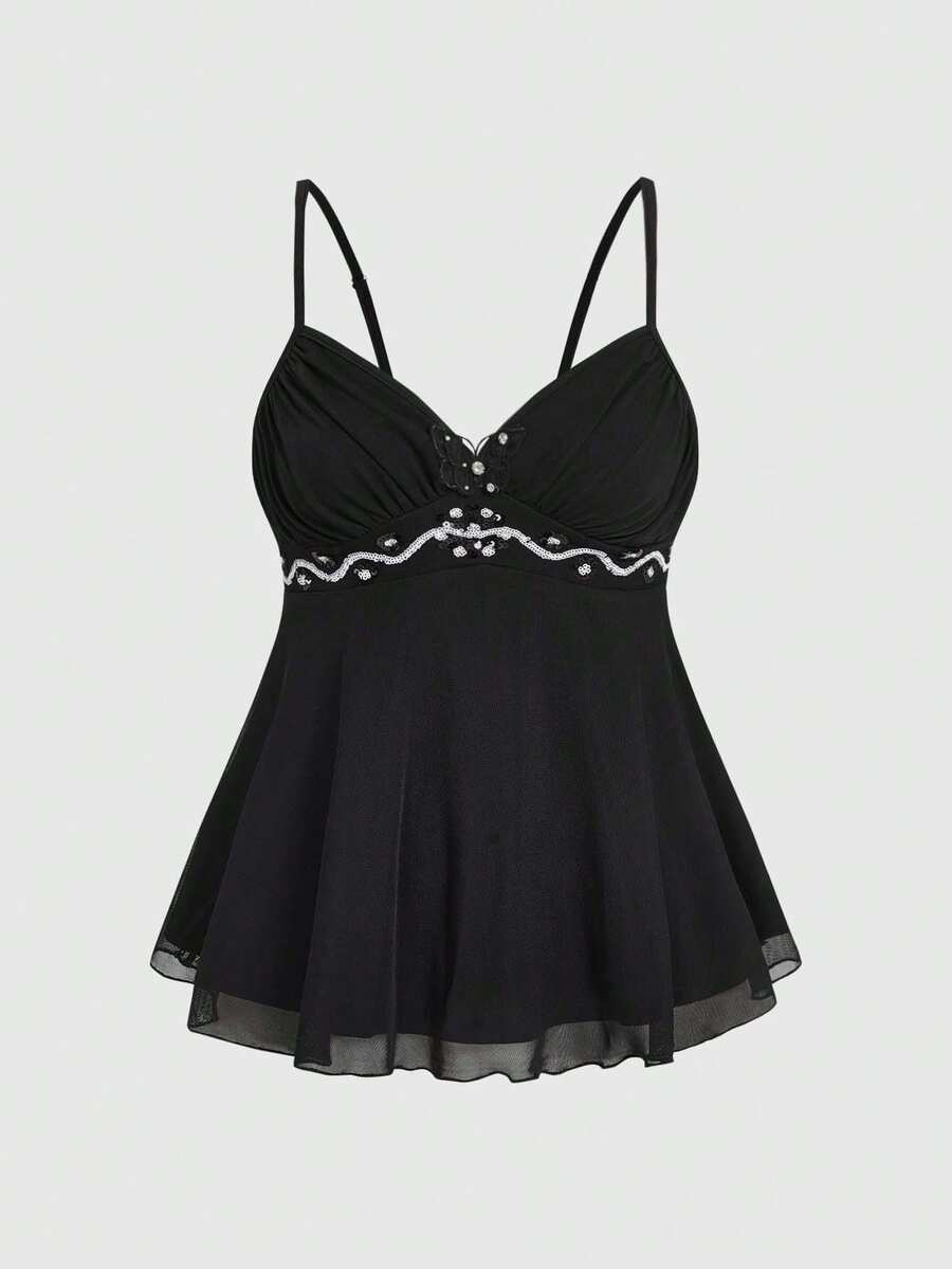 Women's black slim-fit camisole top featuring ruched body design, decorative chain accent, ruffle hem, and cold-shoulder spaghetti straps.