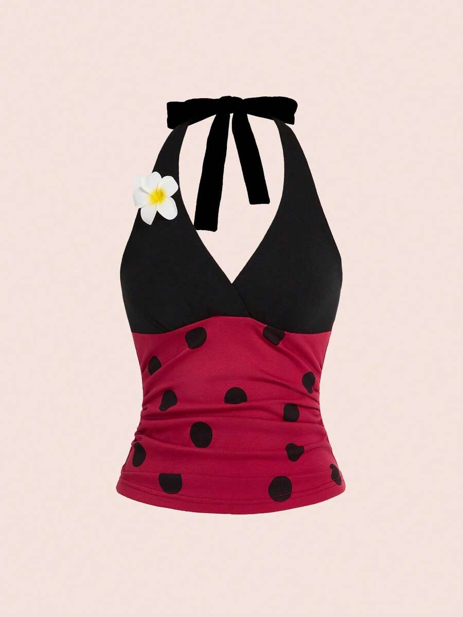 Black and white polka dot halter neck tank top featuring a backless design with ruched knot details and daisy accent.