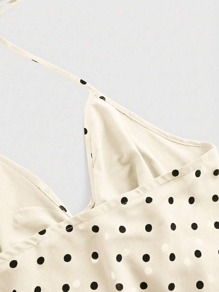 Black halter crop top featuring an asymmetrical ruffle hem and backless design for women.