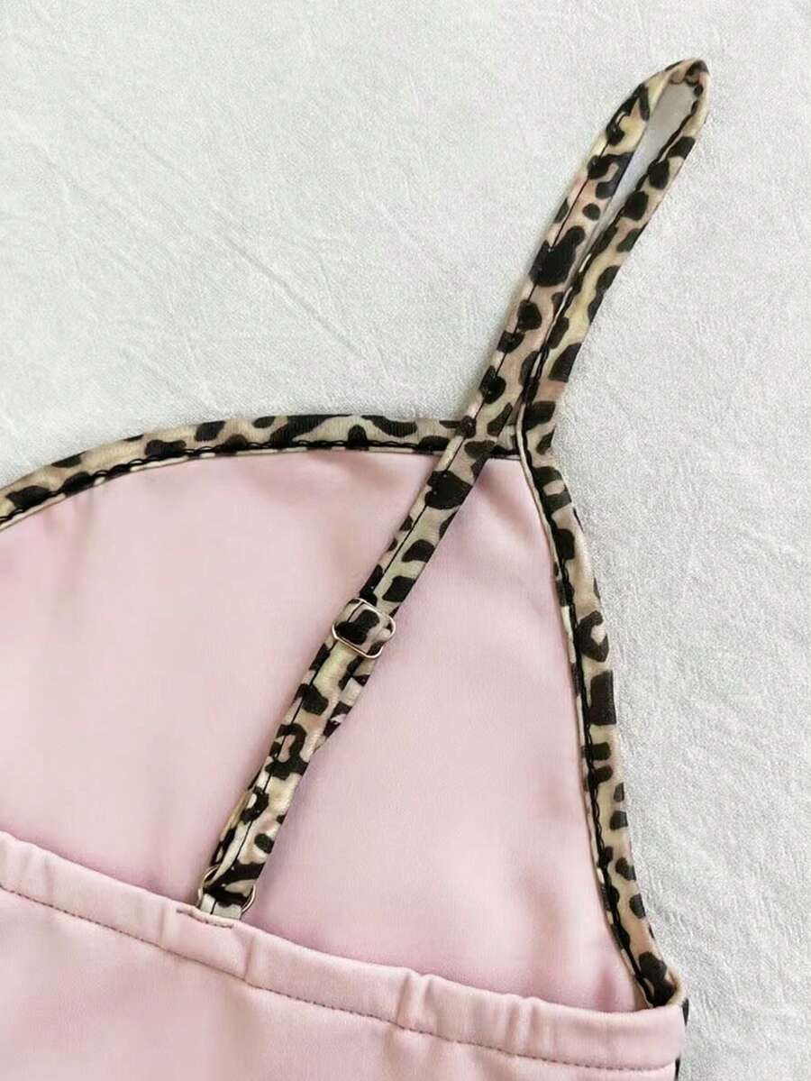 A women's solid slim fit camisole top with delicate contrast lace trim around the neckline and spaghetti straps.