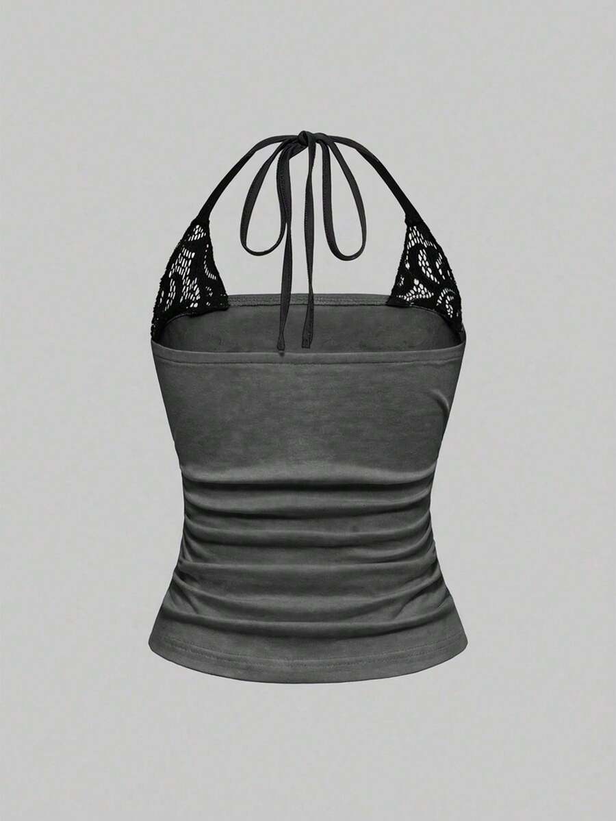 Woman wearing a black Y2K concert print 2-in-1 contrast lace halter crop top featuring a backless design with knot details.