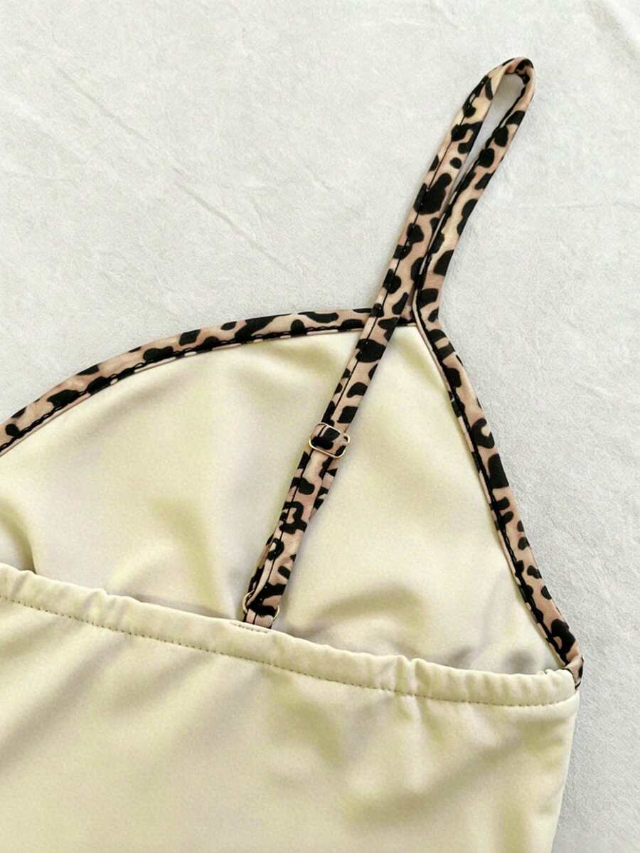 A women's solid slim fit camisole top with delicate contrast lace trim around the neckline and spaghetti straps.