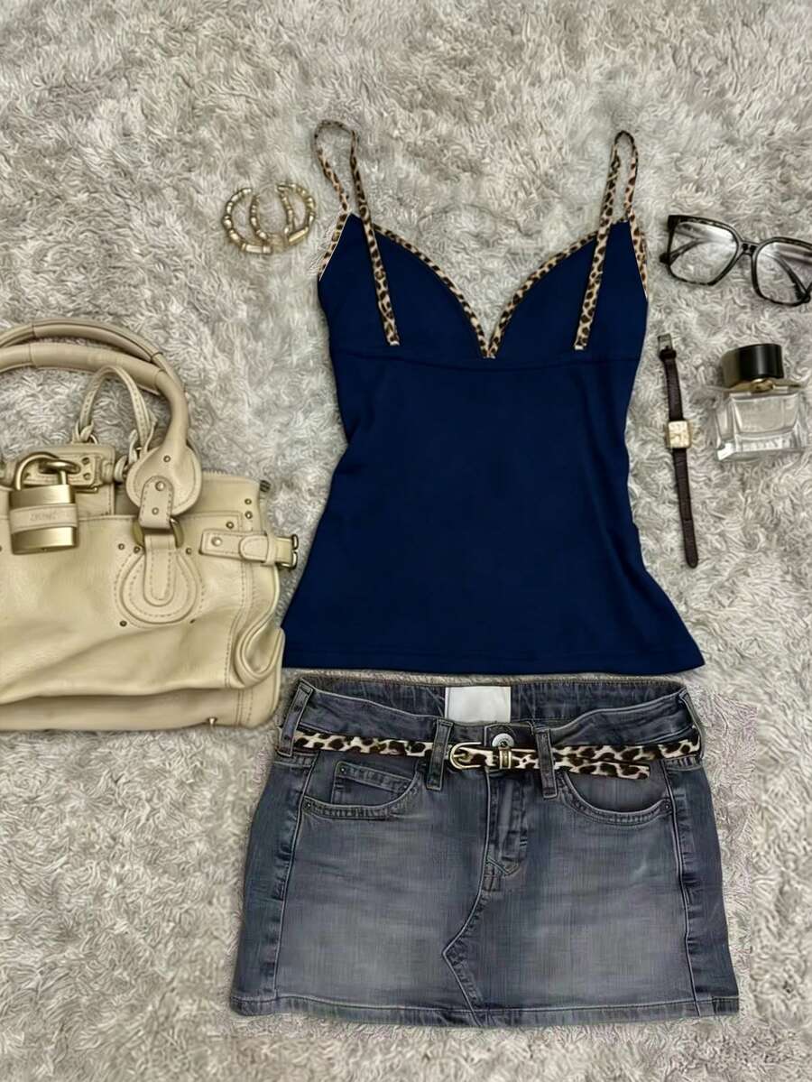 A women's solid slim fit camisole top with delicate contrast lace trim around the neckline and spaghetti straps.