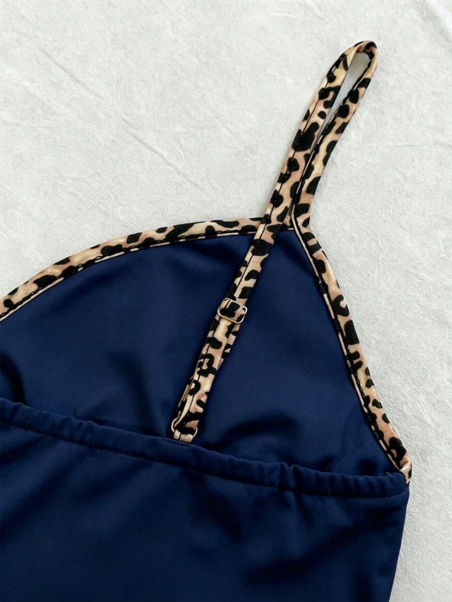 A women's solid slim fit camisole top with delicate contrast lace trim around the neckline and spaghetti straps.