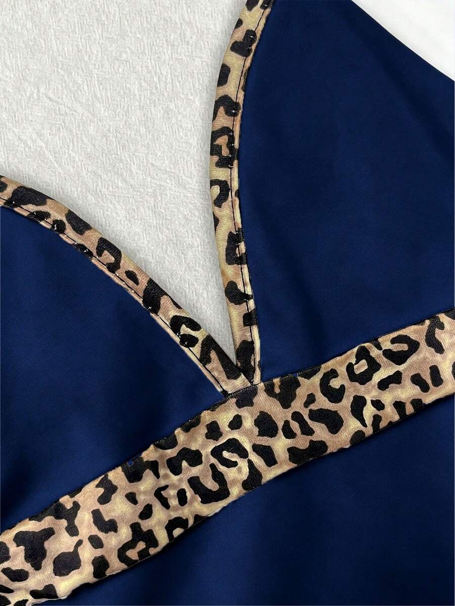 A women's solid slim fit camisole top with delicate contrast lace trim around the neckline and spaghetti straps.