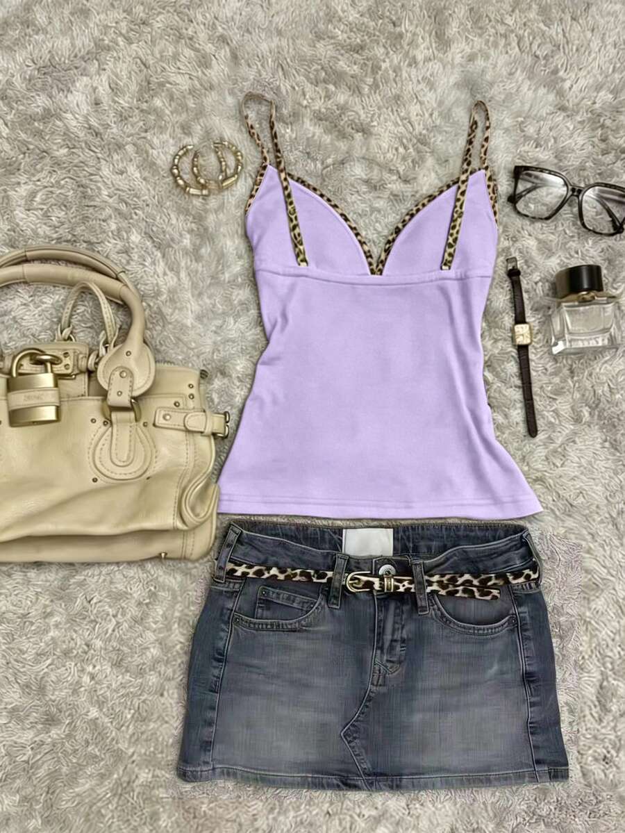 A women's solid slim fit camisole top with delicate contrast lace trim around the neckline and spaghetti straps.
