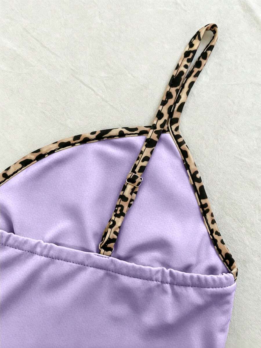 A women's solid slim fit camisole top with delicate contrast lace trim around the neckline and spaghetti straps.