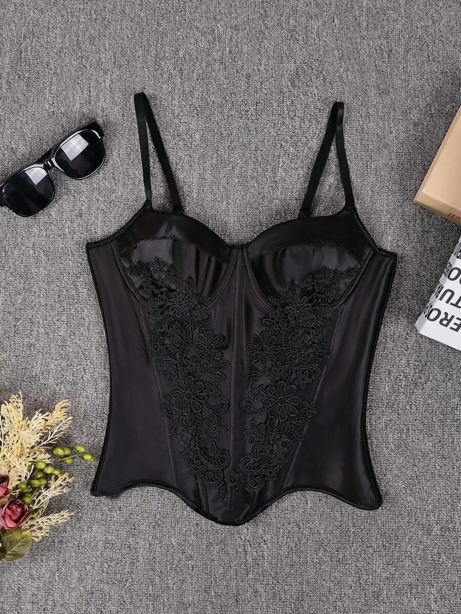 Black satin corset top for women with 3D floral rose details, boned slim-fit bodice, thin spaghetti straps, lace-up open back, and asymmetrical curved hem.