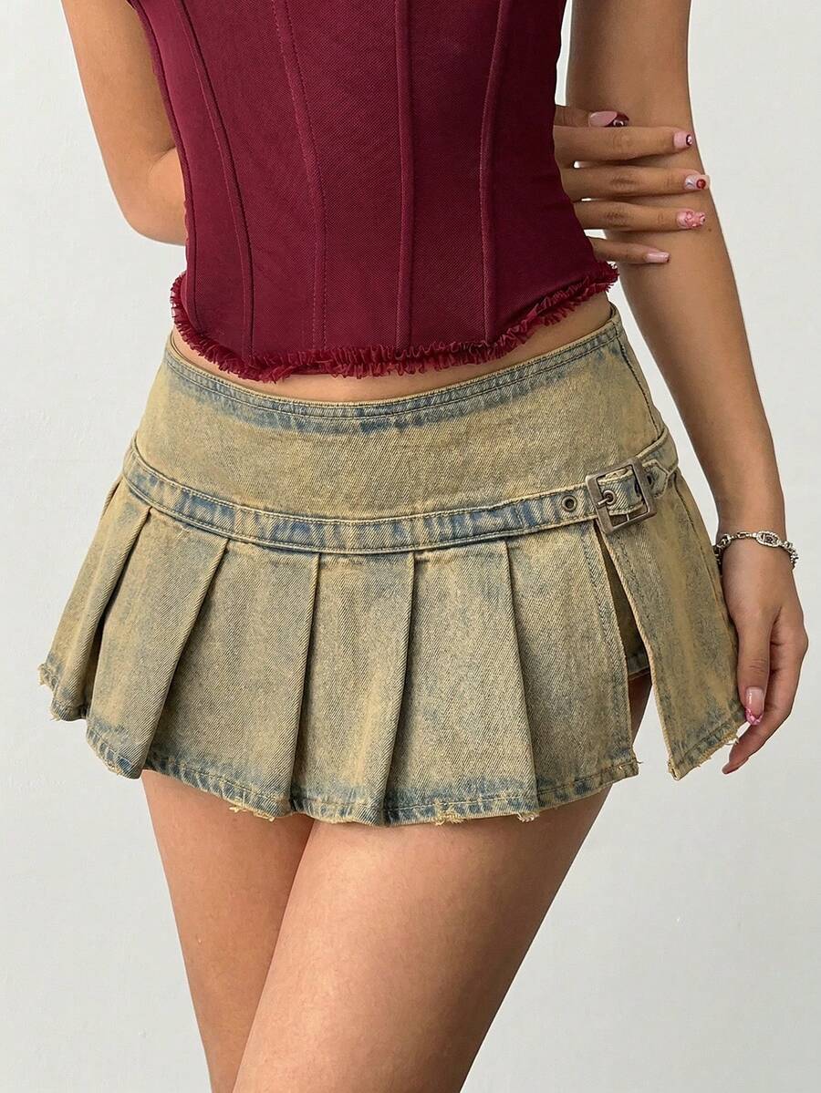 Women's blue denim pleated mini skirt skort featuring a low waist fit with zipper and grommet eyelet details.