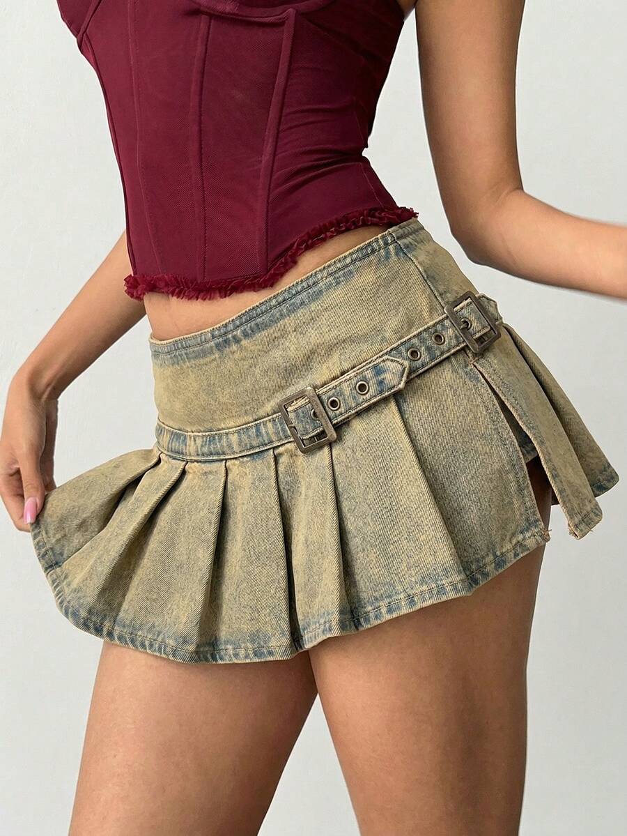Women's blue denim pleated mini skirt skort featuring a low waist fit with zipper and grommet eyelet details.