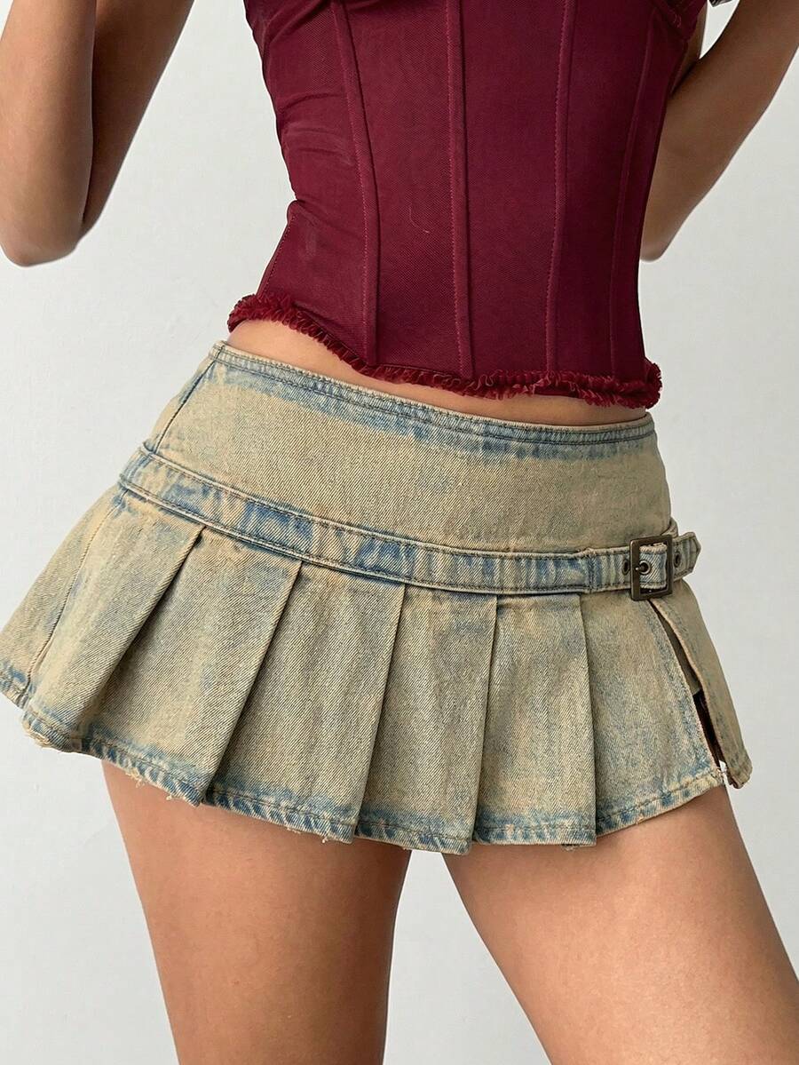 Women's blue denim pleated mini skirt skort featuring a low waist fit with zipper and grommet eyelet details.