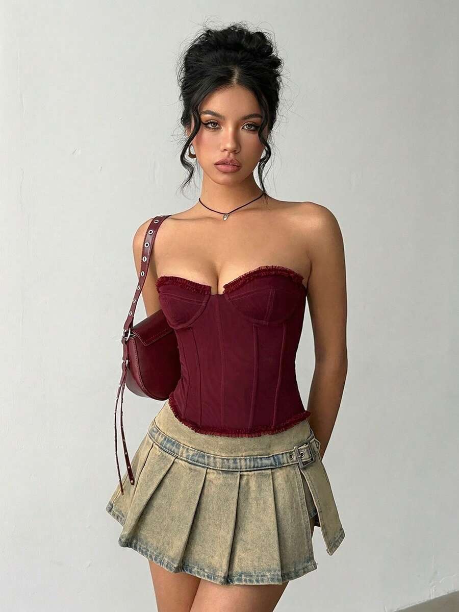 Women's blue denim pleated mini skirt skort featuring a low waist fit with zipper and grommet eyelet details.