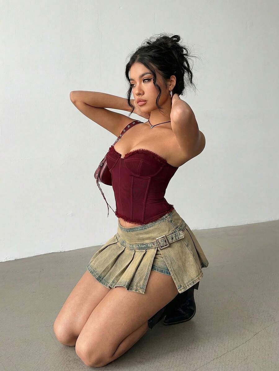 Women's blue denim pleated mini skirt skort featuring a low waist fit with zipper and grommet eyelet details.