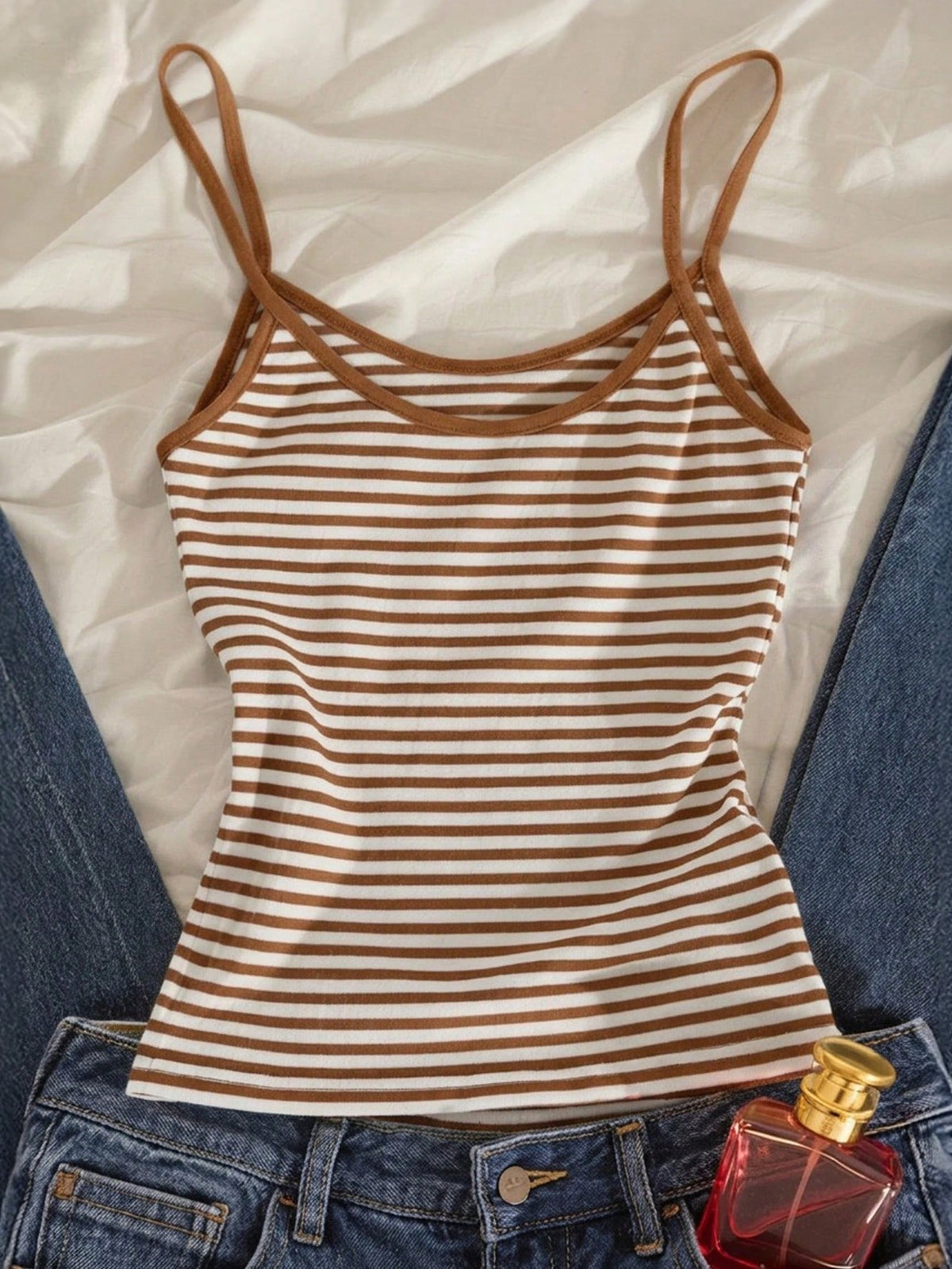 Women's pink striped crop camisole featuring criss cross spaghetti straps and slim fit design.