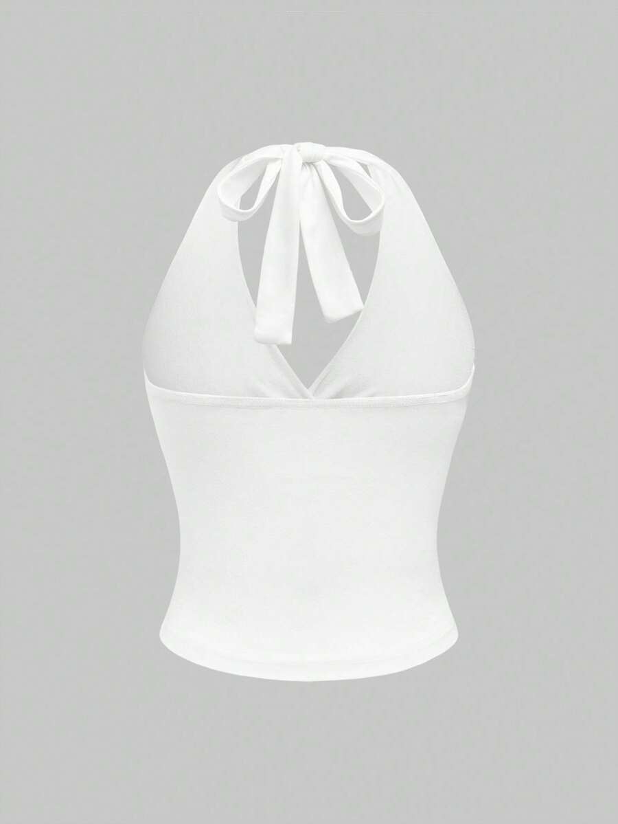 Women's halter crop tank top featuring a backless silhouette and ruched detailing in a slim fit design.