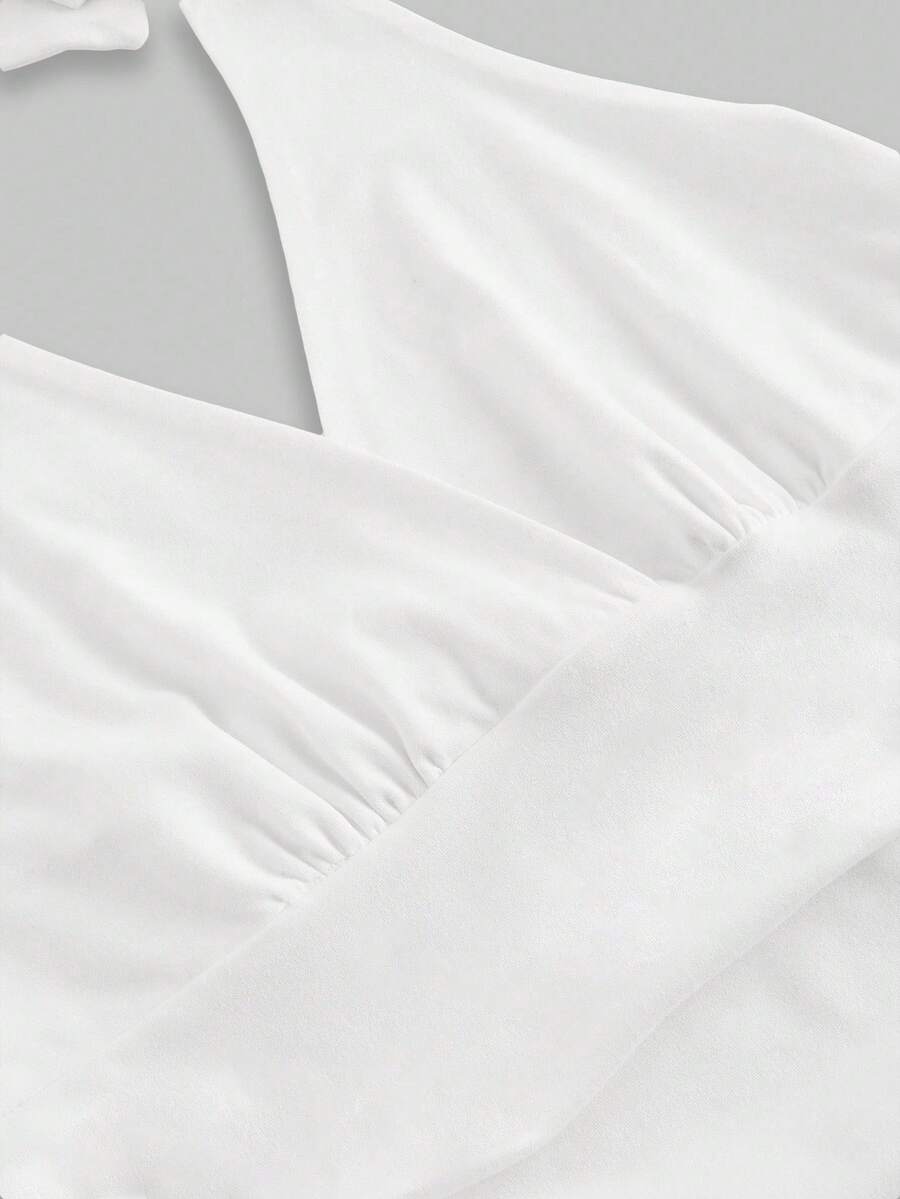 Women's halter crop tank top featuring a backless silhouette and ruched detailing in a slim fit design.