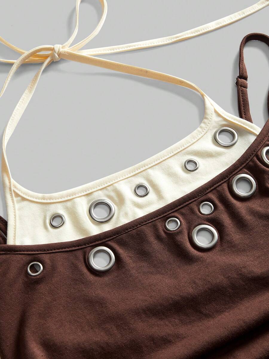 Black halter crop tank top for women featuring lace up front details, ruched accents, and appliques in a slim fit knitted fabric.