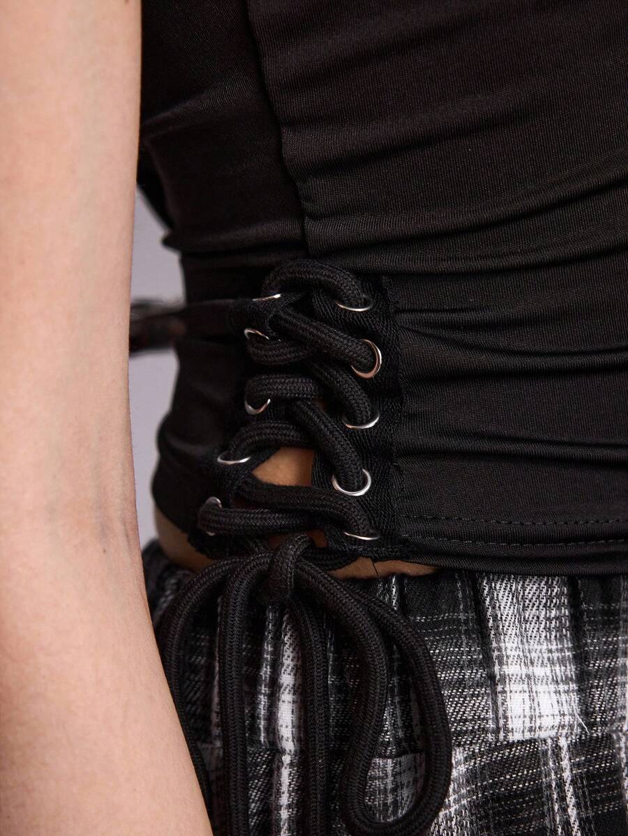Women's black asymmetrical shoulder tie cami top with metallic ring detail and slim fit design.