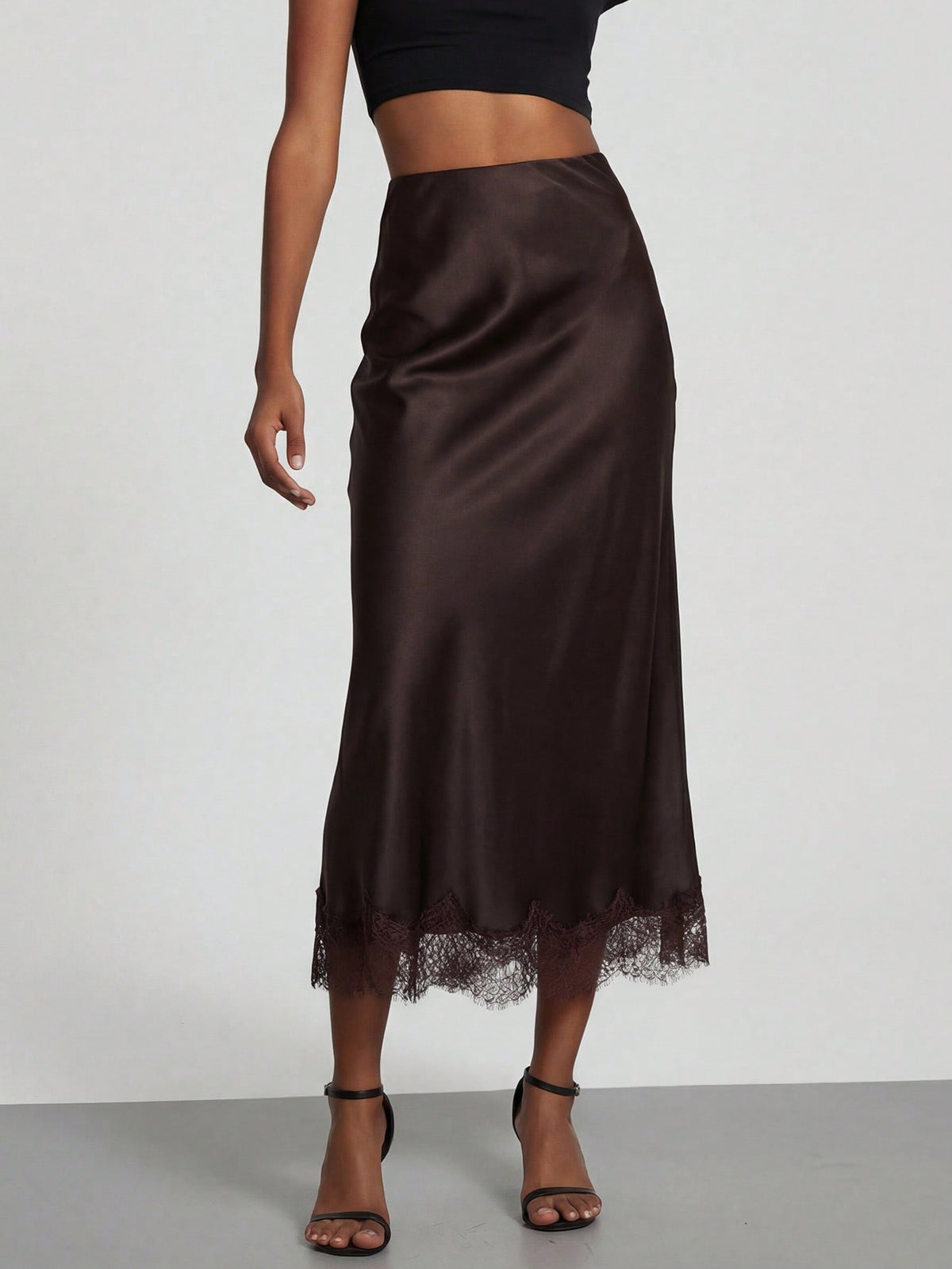 Women's black lace patchwork satin skirt featuring a long bodycon silhouette and natural mid waist design.