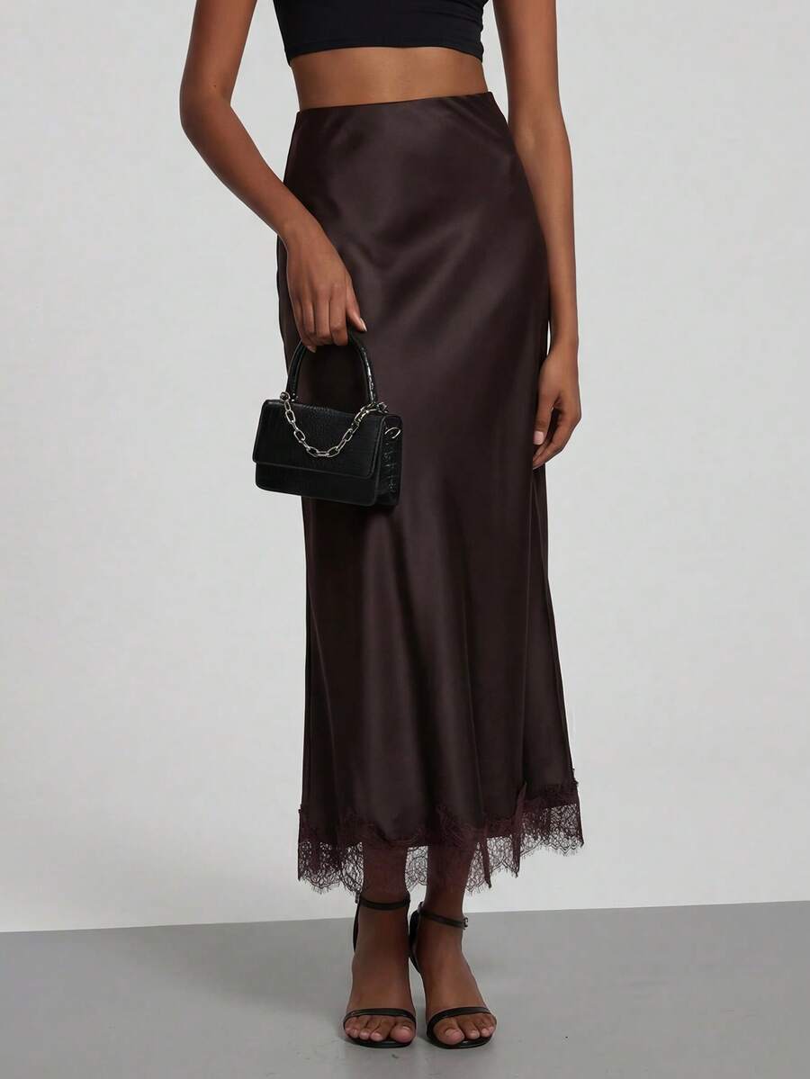 Women's black lace patchwork satin skirt featuring a long bodycon silhouette and natural mid waist design.