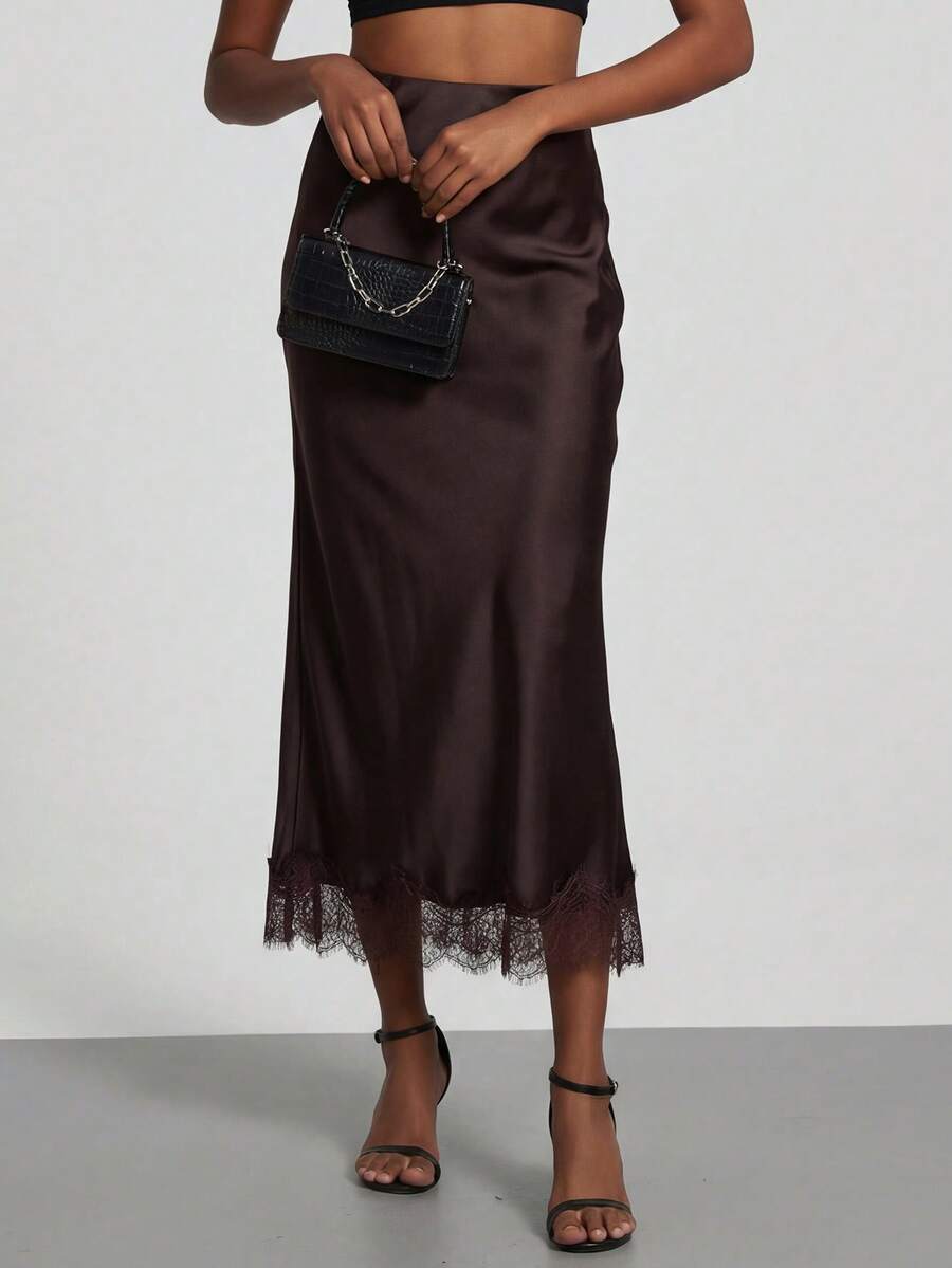 Women's black lace patchwork satin skirt featuring a long bodycon silhouette and natural mid waist design.