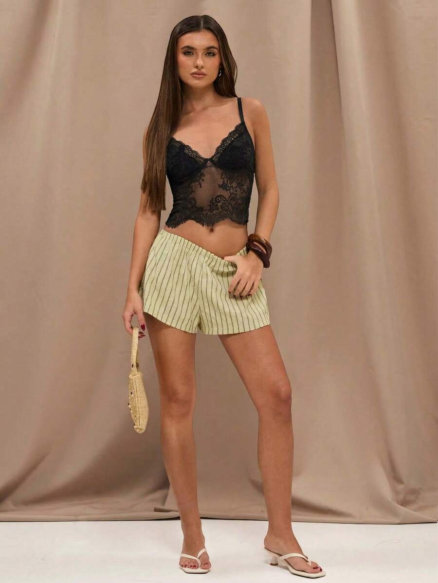 Black floral lace cropped camisole top for women featuring delicate spaghetti straps, cup detail, and semi-sheer contrast lace.