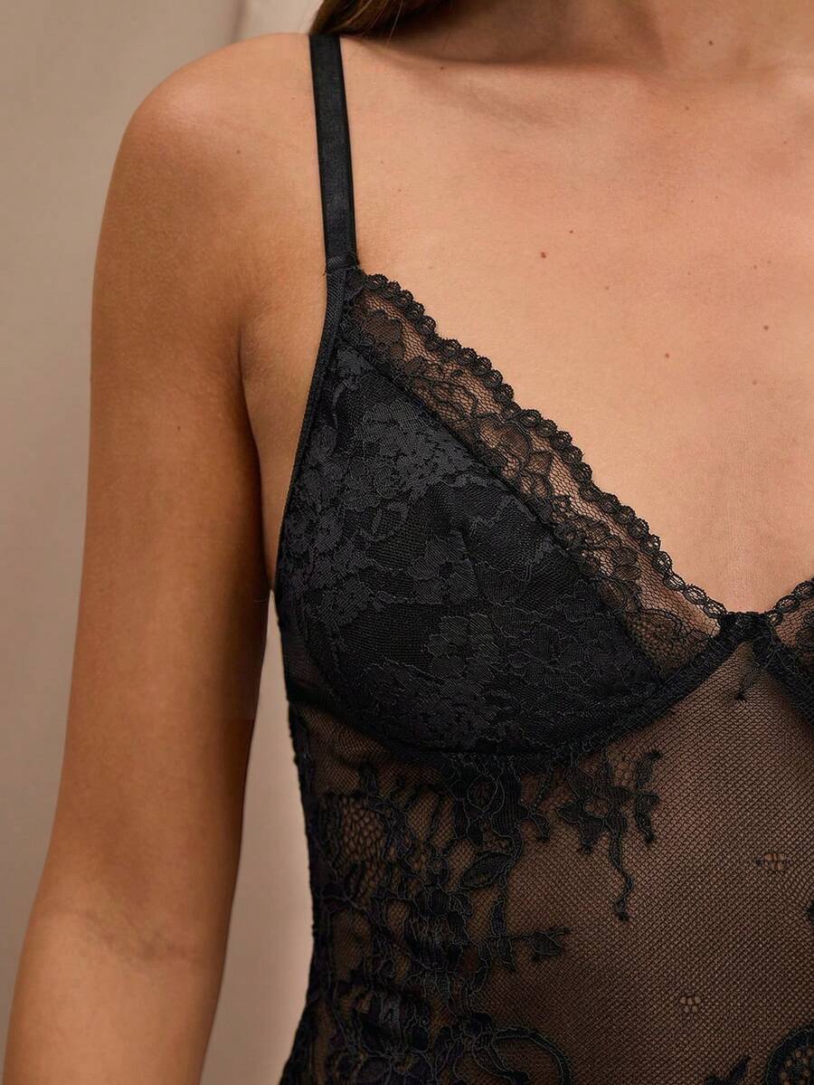 Black floral lace cropped camisole top for women featuring delicate spaghetti straps, cup detail, and semi-sheer contrast lace.