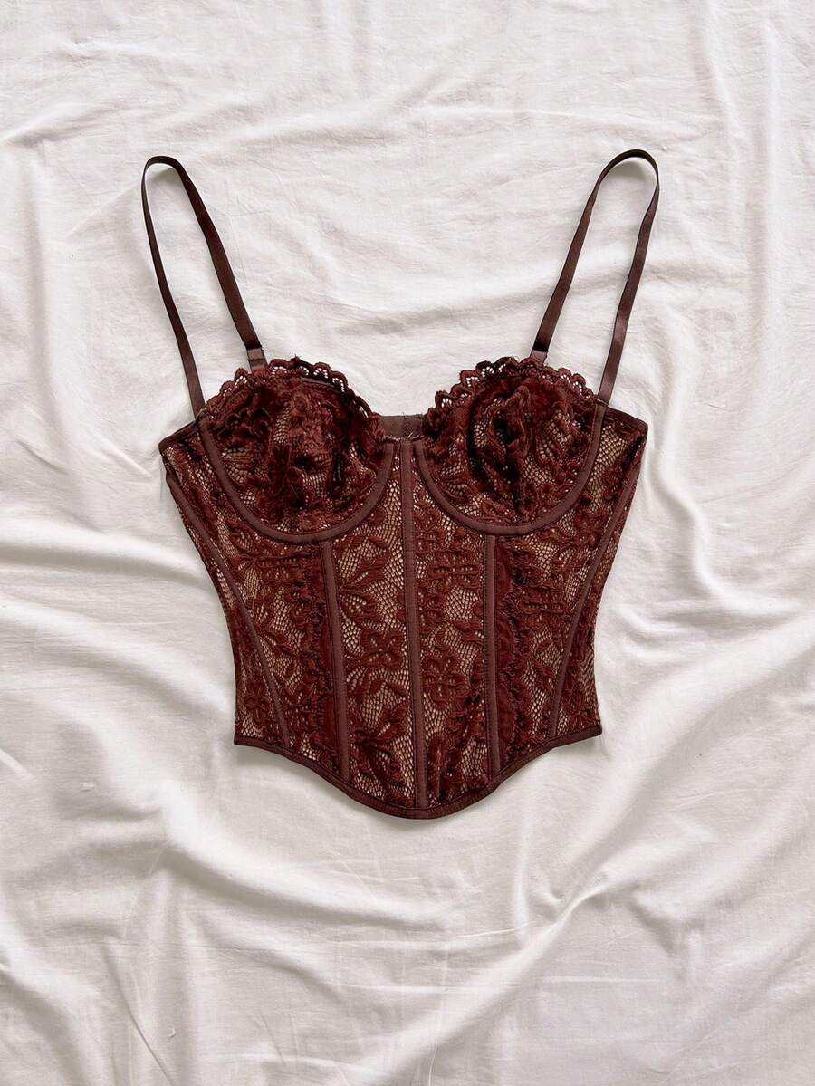 Women's lace bustier camisole top with spaghetti straps, contrast lace, lace-up detail, and an asymmetrical hem in a slim fit design.
